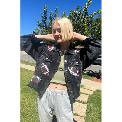 Black corduroy jacket with sequin football patches worn outdoors, women's game day outfit