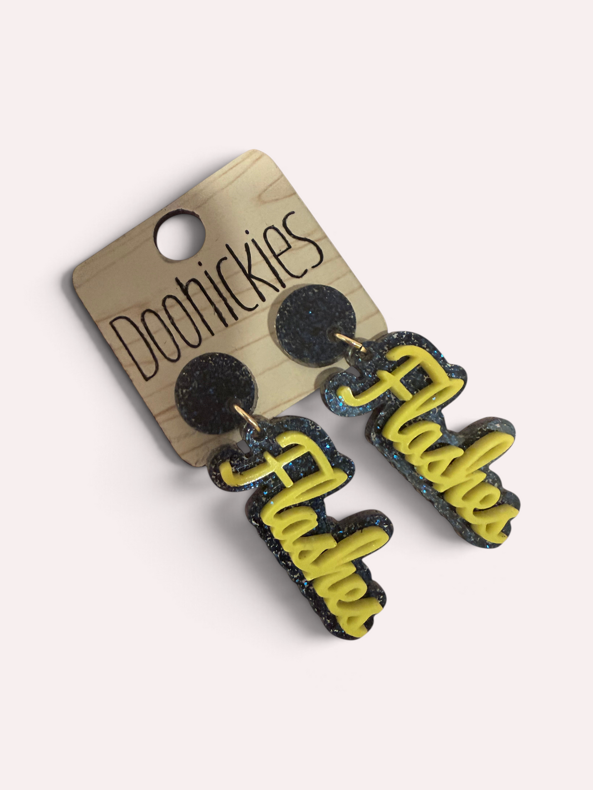 Close up of layered gold and navy glitter Flashes earrings on stainless steel posts