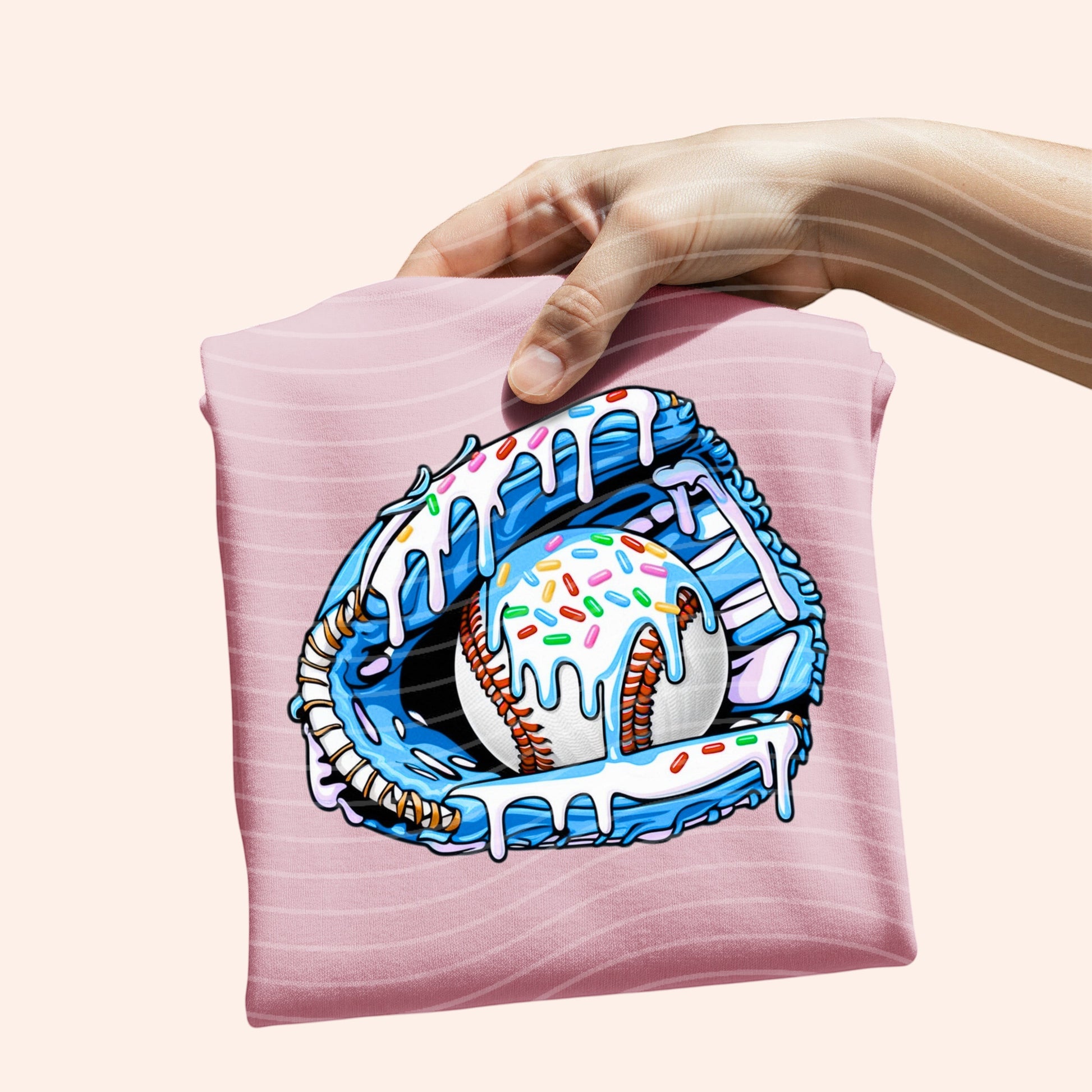 Bleacher Babe pink graphic tee with a blue baseball glove holding a baseball covered in blue icing and sprinkles.