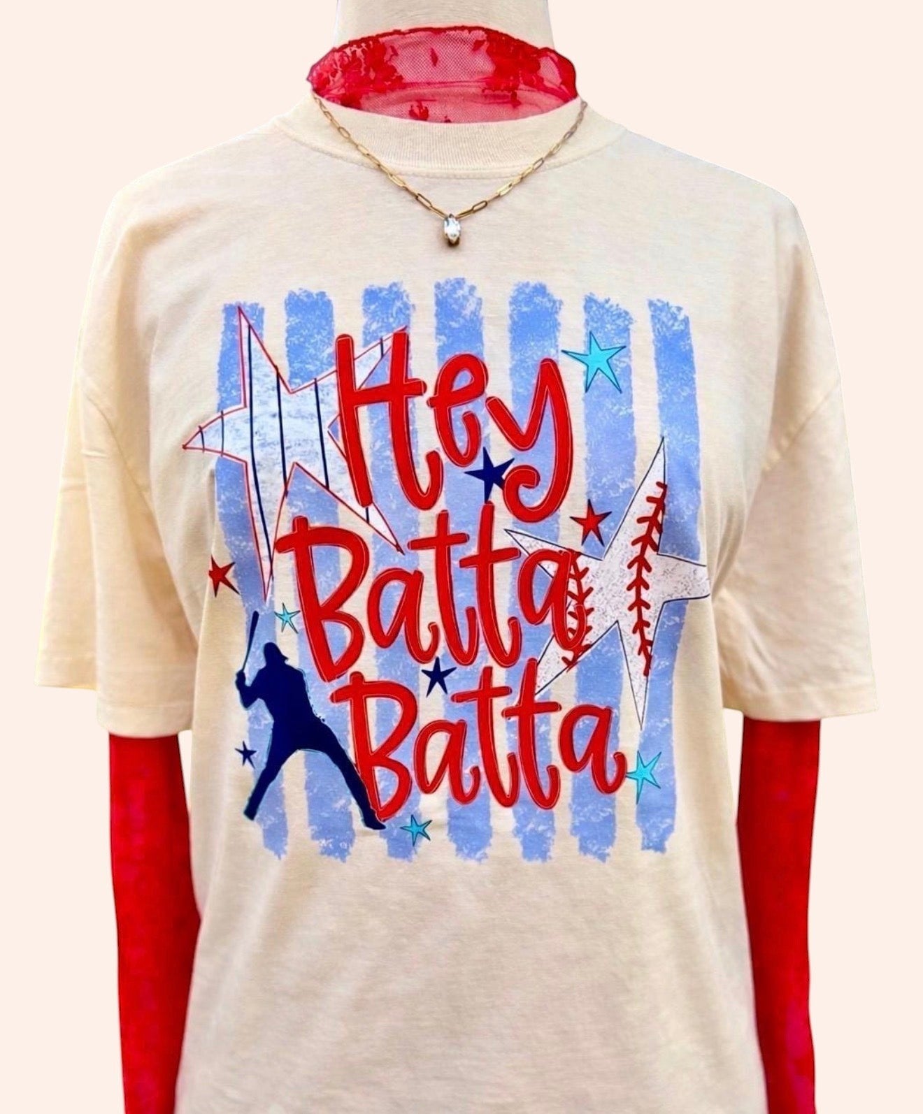Bleacher Babe cream graphic tee with red "Hey Batter Batter" text, baseball, stars, and blue stripes.
