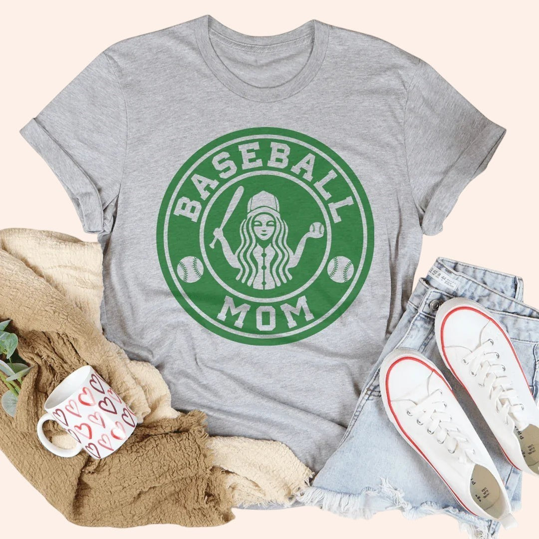 Bleacher Babe grey graphic tee with "Baseball Mom" in a green circular logo. Short sleeves, relaxed fit.