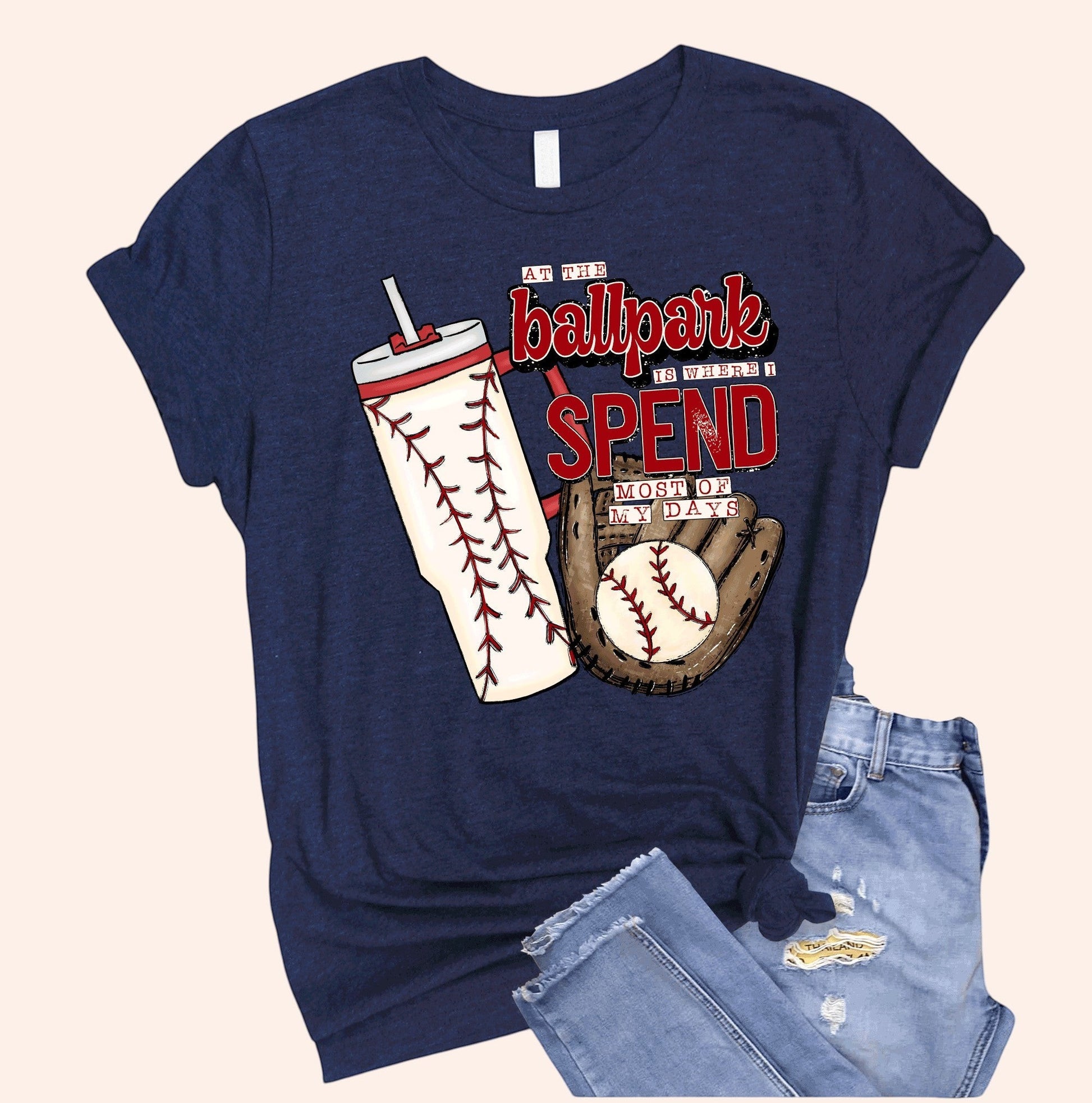Bleacher Babe navy blue baseball mom graphic tee with baseball, glove, and tumbler design. Soft cotton.
