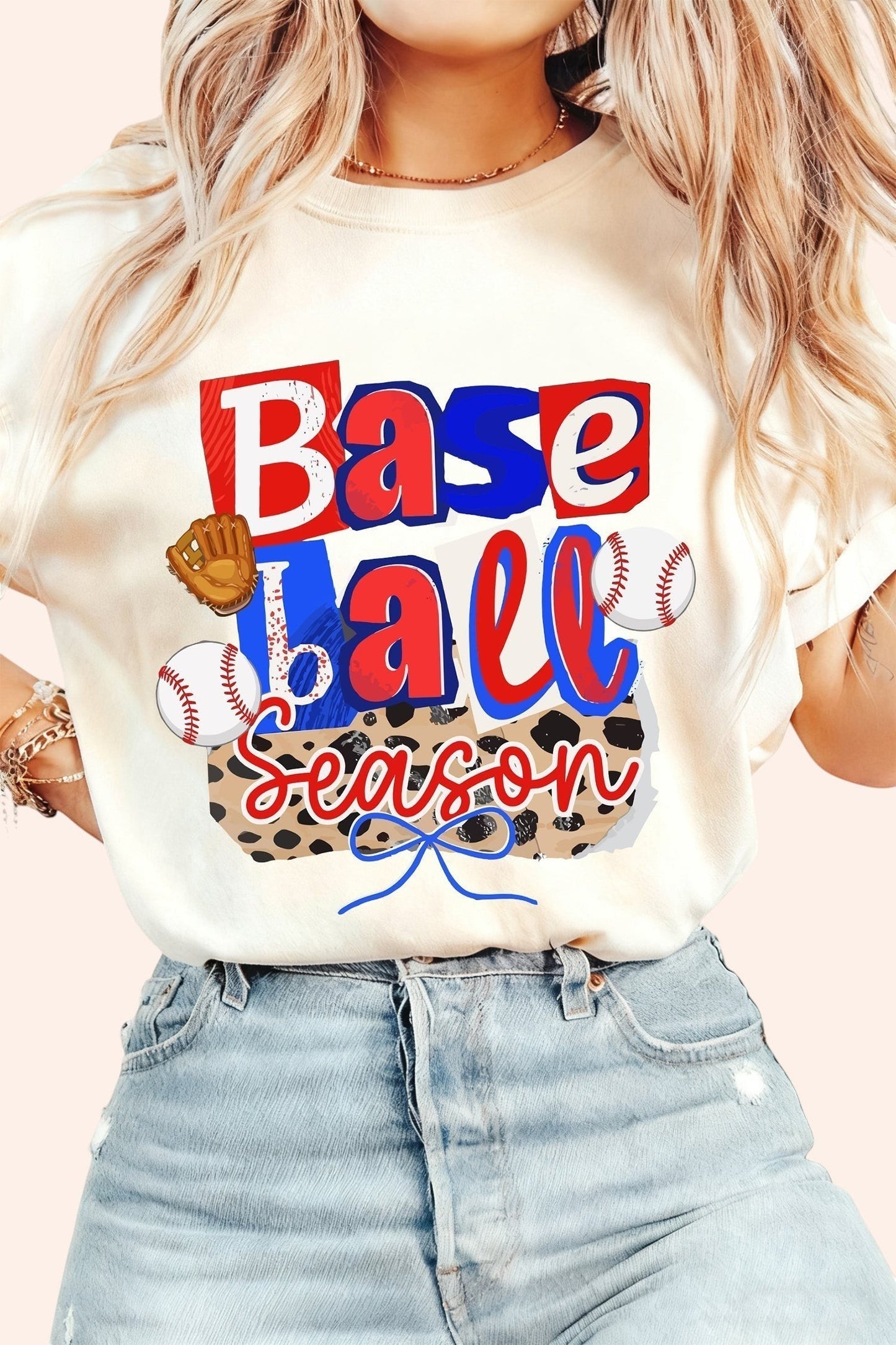 Bleacher Babe cream graphic t-shirt with "Baseball Season" print, baseballs, and glove. Short sleeves, crew neck.