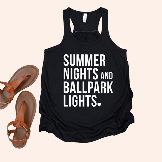 Bleacher Babe black racerback tank top with white text reading "SUMMER NIGHTS AND BALLPARK LIGHTS."