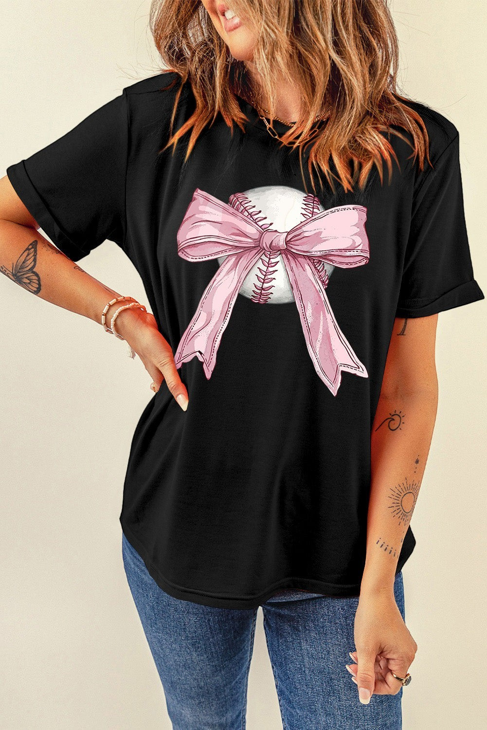 Bleacher Babe black baseball tee with a pink bow graphic on a baseball.