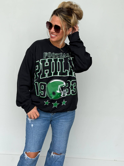 Bleacher Babe black unisex sweatshirt with vintage green Philly football screen print worn by a woman in sunglasses