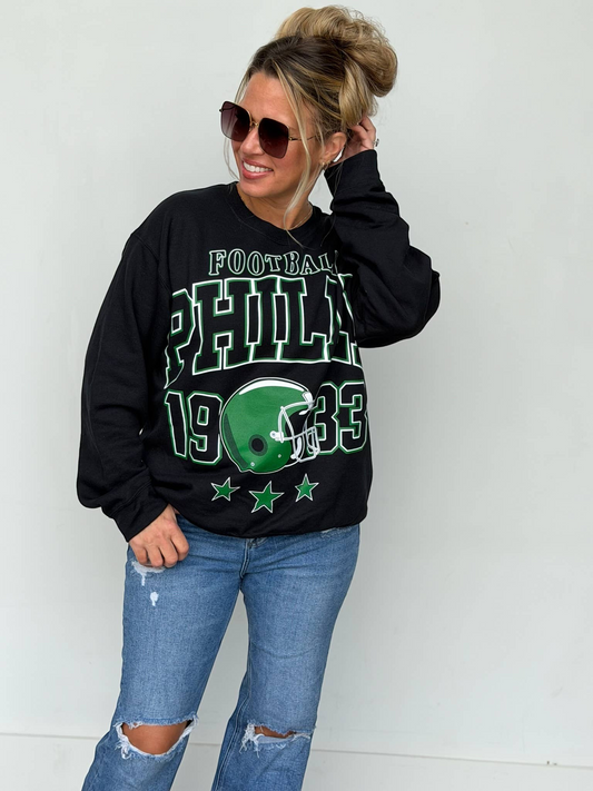 Bleacher Babe black unisex sweatshirt with vintage green Philly football screen print worn by a woman in sunglasses