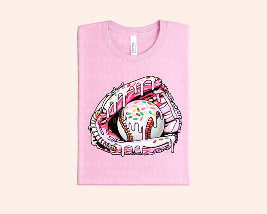 Bleacher Babe pink graphic tee with a baseball glove holding a baseball covered in pink frosting and sprinkles.