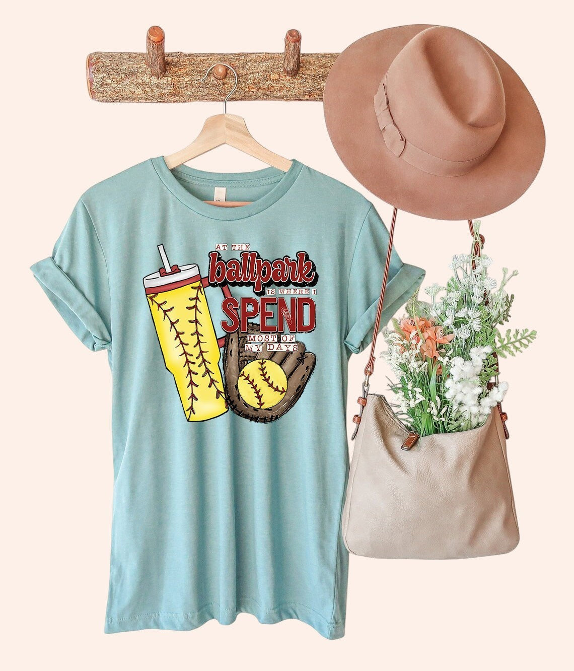 Bleacher Babe light blue graphic tee with softball "At the Ballpark Spend Most of My Days" design, featuring a tumbler and glove.