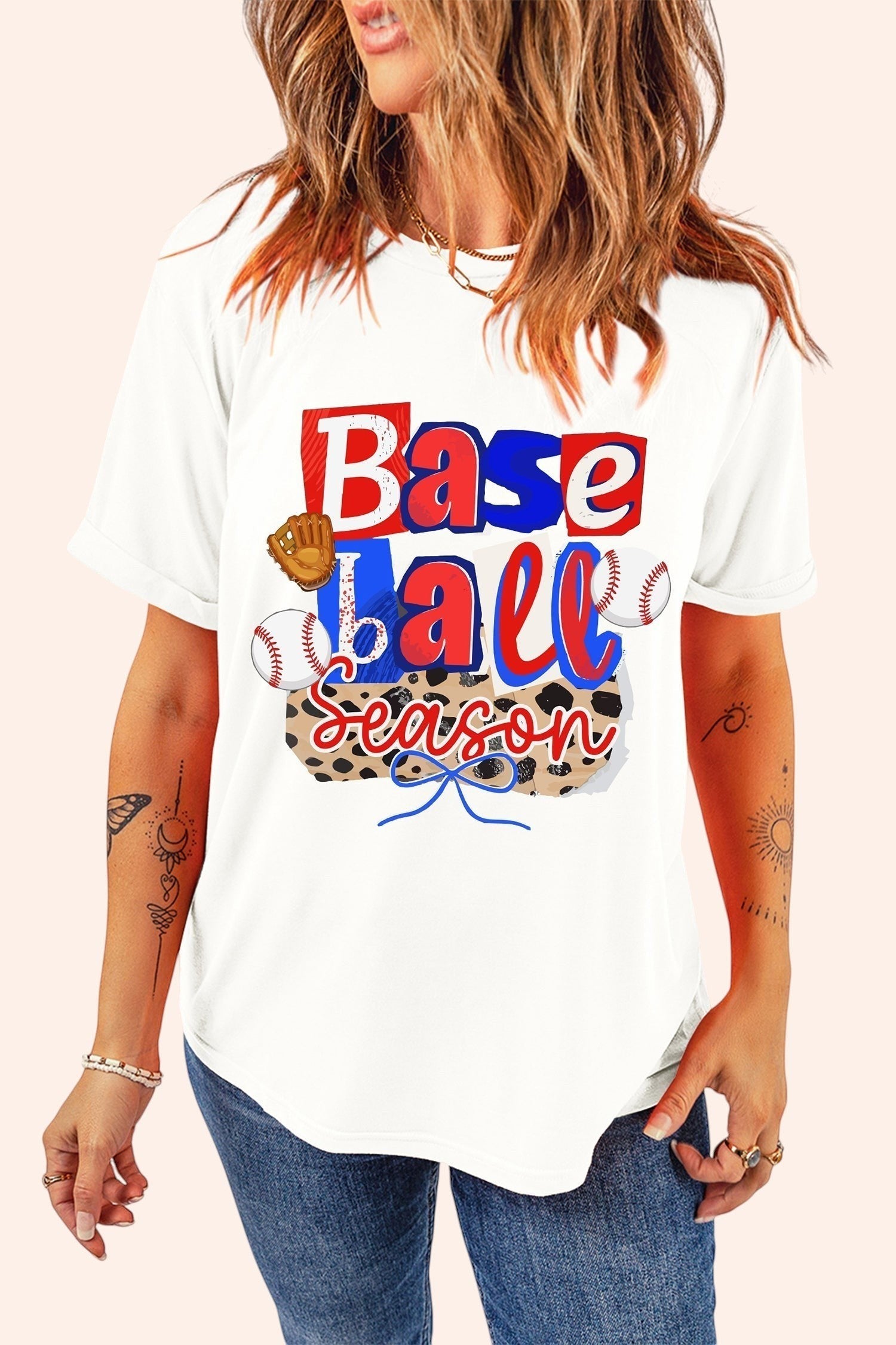Bleacher Babe white cotton t-shirt with playful "Baseball Season" graphic featuring baseballs, glove, and leopard print.