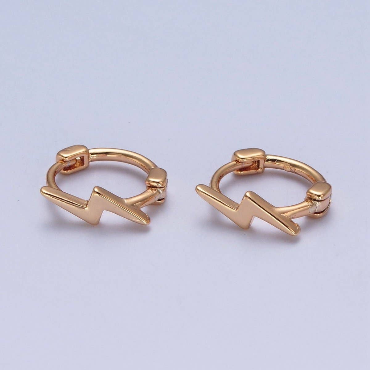 Gold lightning bolt huggie hoop earrings by Aim Eternal – dainty pair on light background